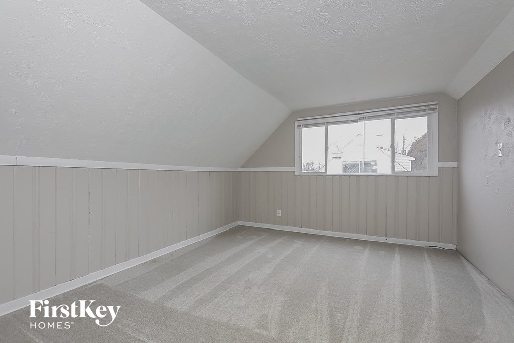 the living room of a house with white walls and a window