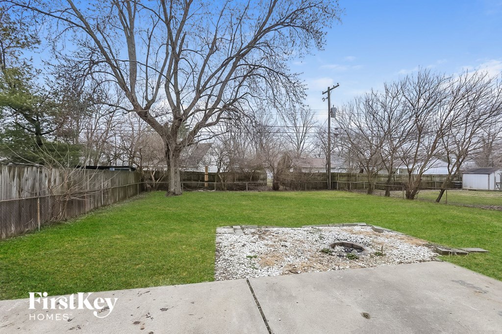 a backyard with a grass lawn and a fence