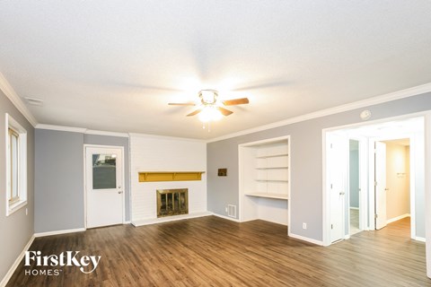 a living room with a ceiling fan and a fireplace