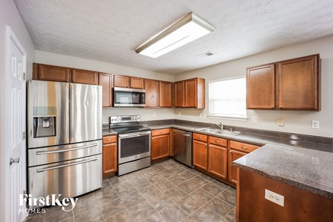 A kitchen with wooden cabinets and a stainless steel refrigerator.