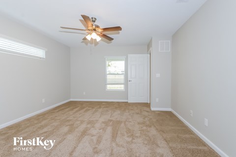 the master bedroom is spacious and has a ceiling fan