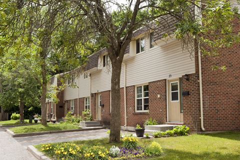 Tamarack Woods Several townhouse exteriors next to each other with neatly clipped green grass and lush trees in Barrie, ON