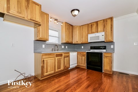 A kitchen with wooden cabinets and a black oven.