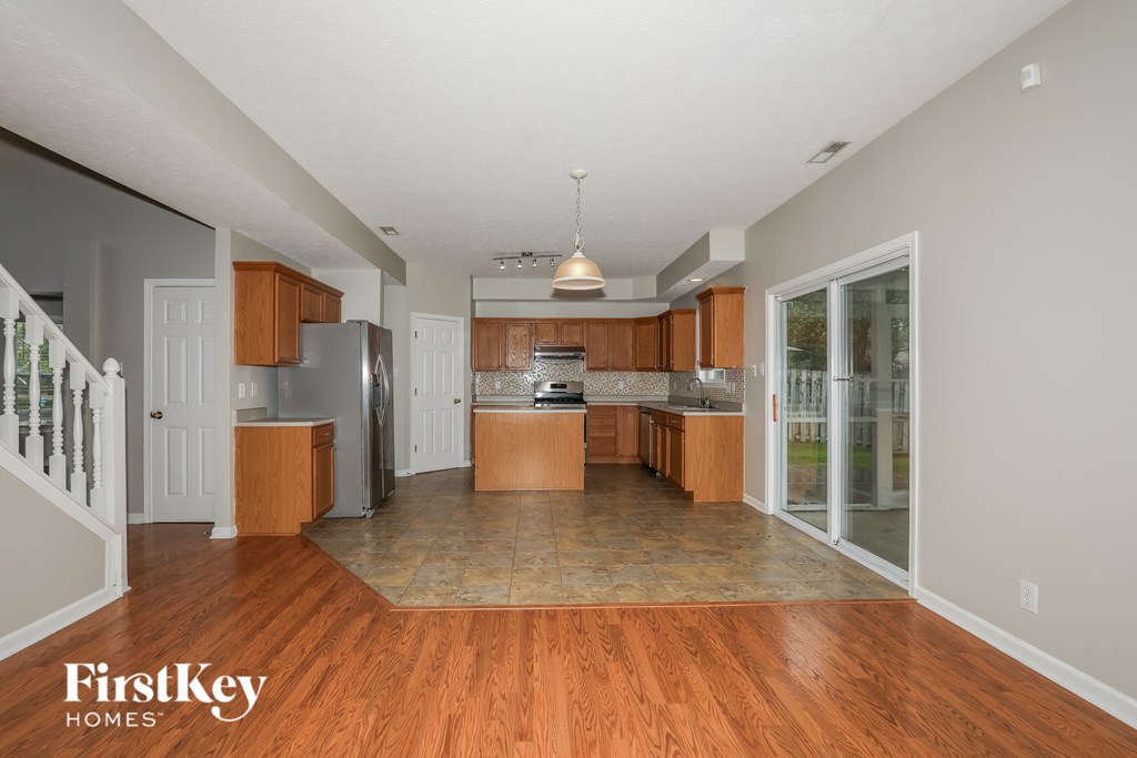 A kitchen with wooden floors and a refrigerator.