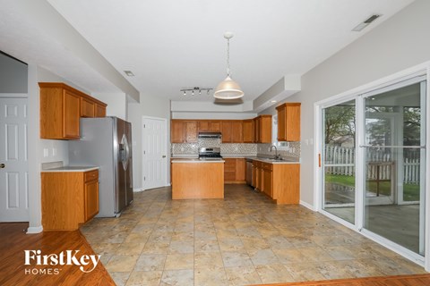 A kitchen with wooden cabinets and a tiled floor.