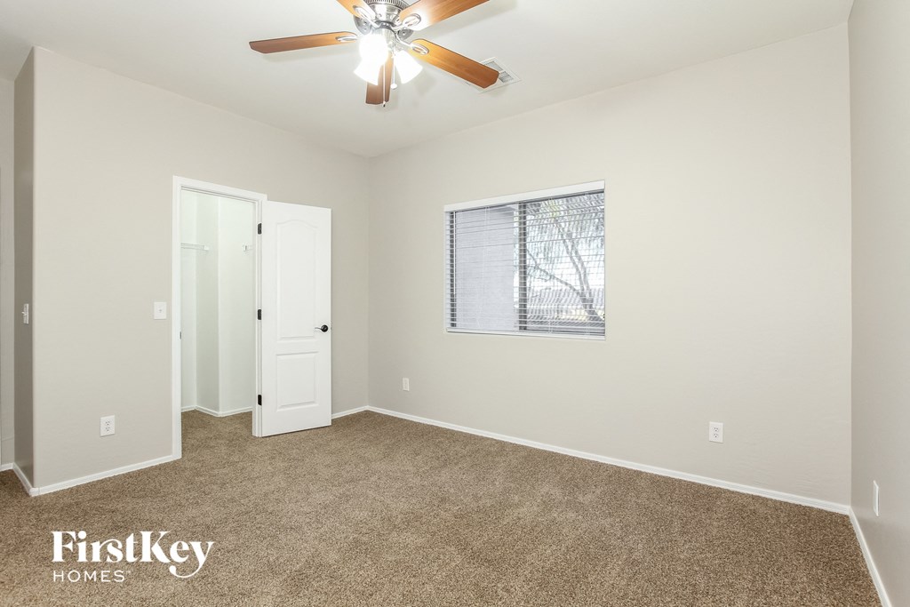 a living room with carpet and a ceiling fan