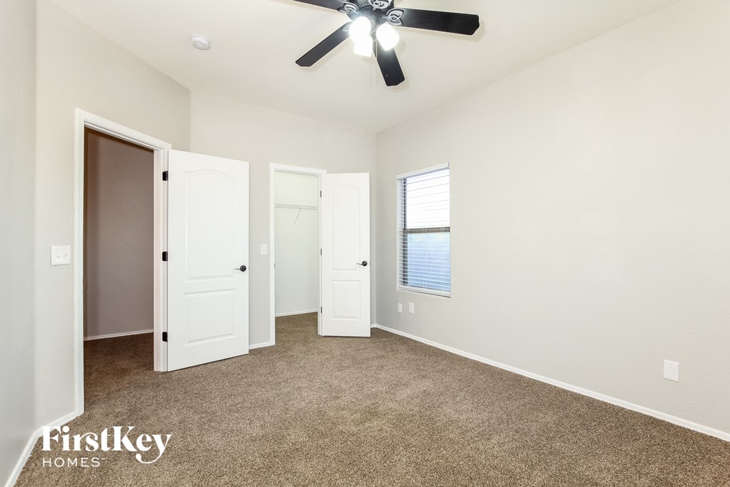 a living room with carpet and a ceiling fan