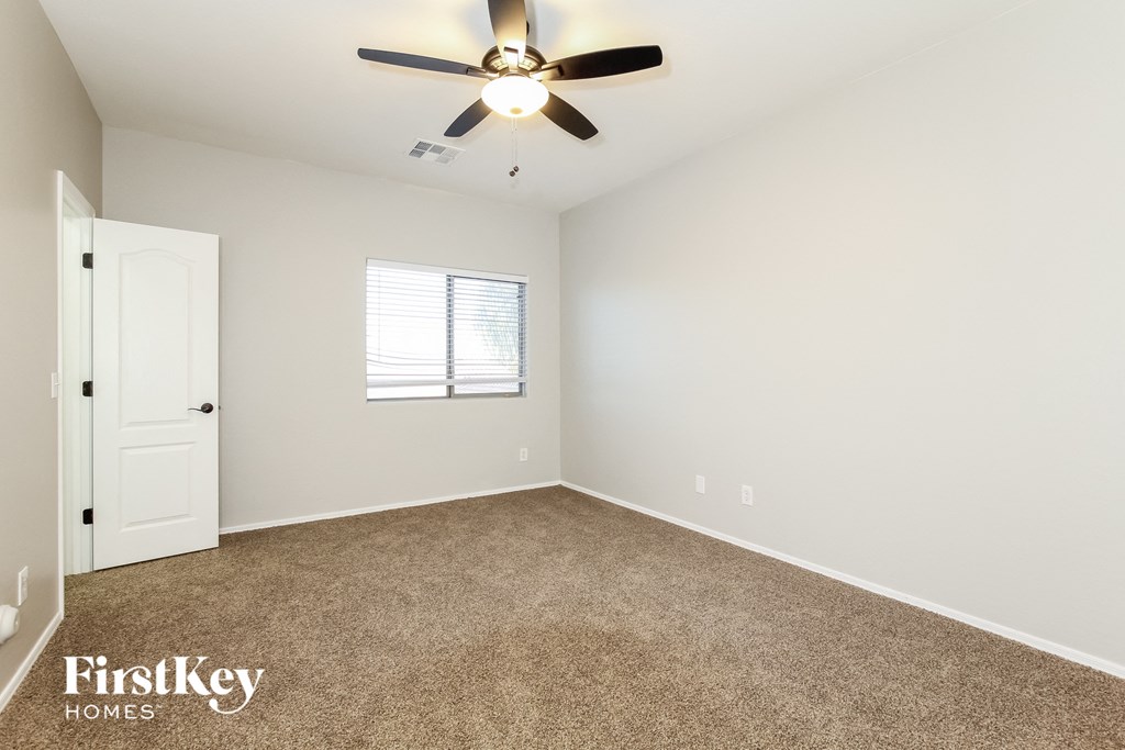 a room with carpet and a ceiling fan