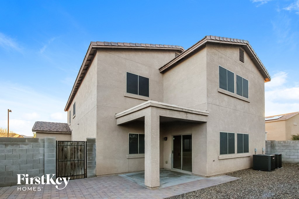 a beige house with a driveway and a gate