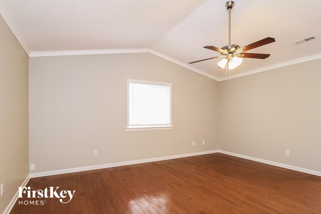 A room with a ceiling fan and a window.