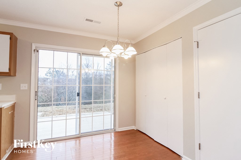 A room with a large window and a chandelier hanging from the ceiling.