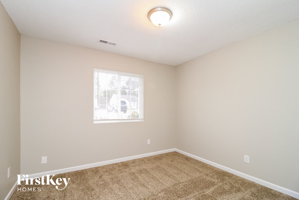A room with a carpeted floor and a window.