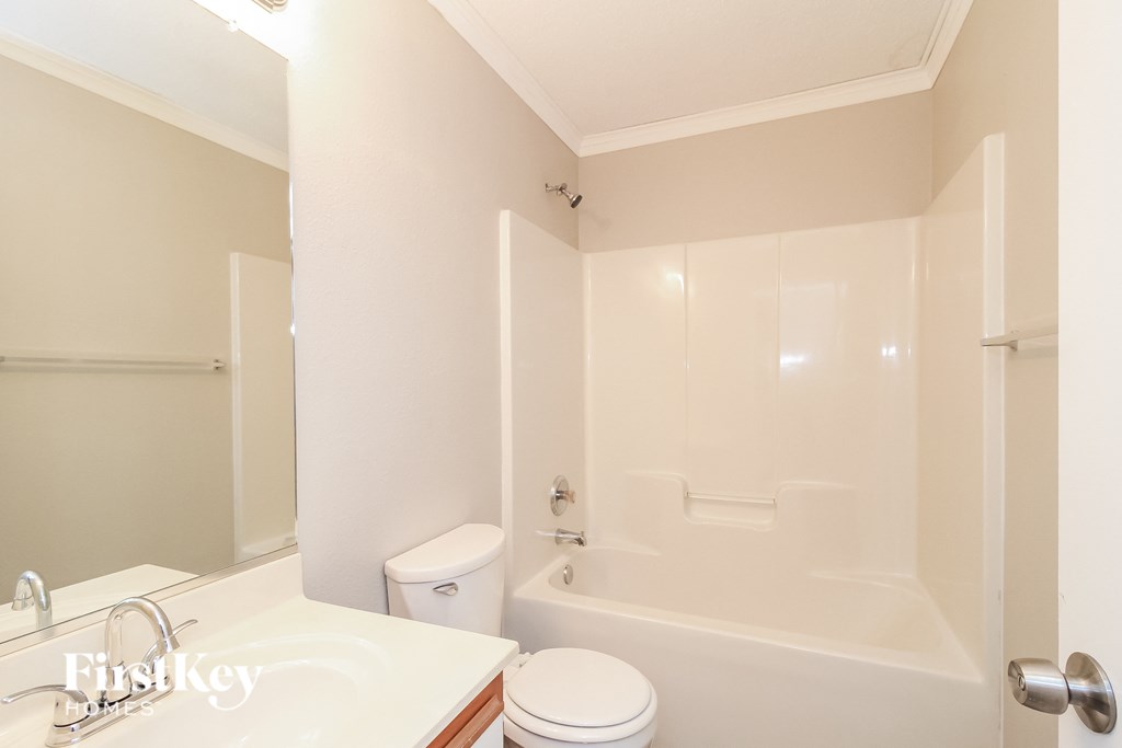 A white bathroom with a toilet, sink, and bathtub.