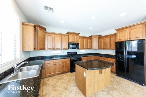 A kitchen with wooden cabinets and black appliances.