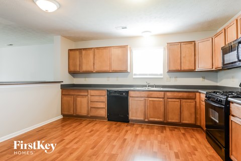 A kitchen with wooden cabinets and black appliances.
