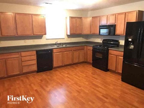 a kitchen with wood floors and black appliances