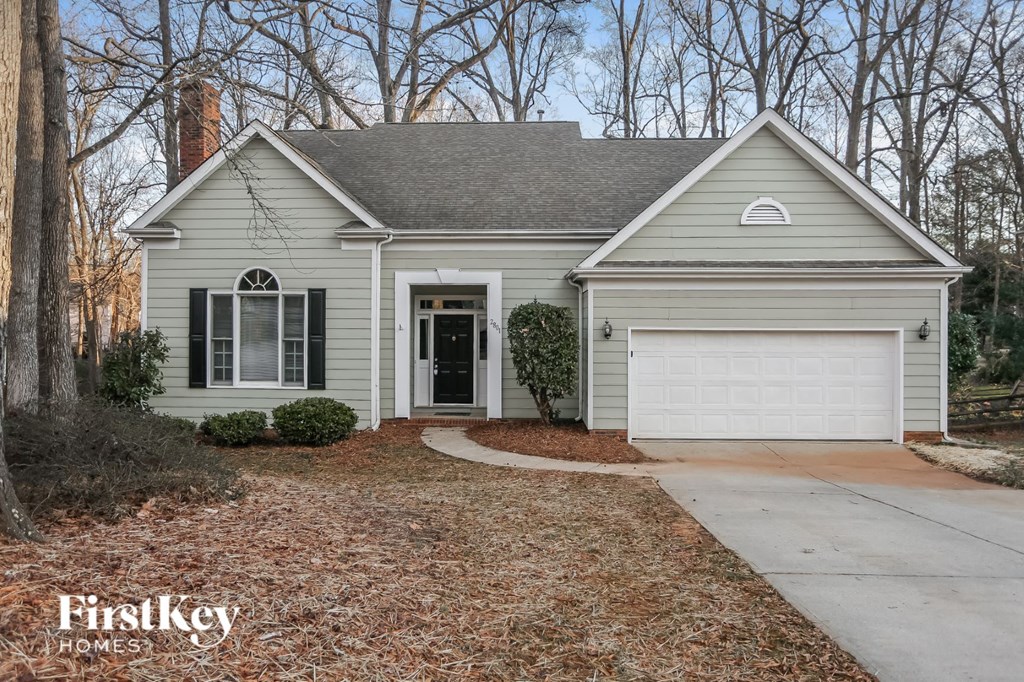 A house with a garage and a driveway in front of it.