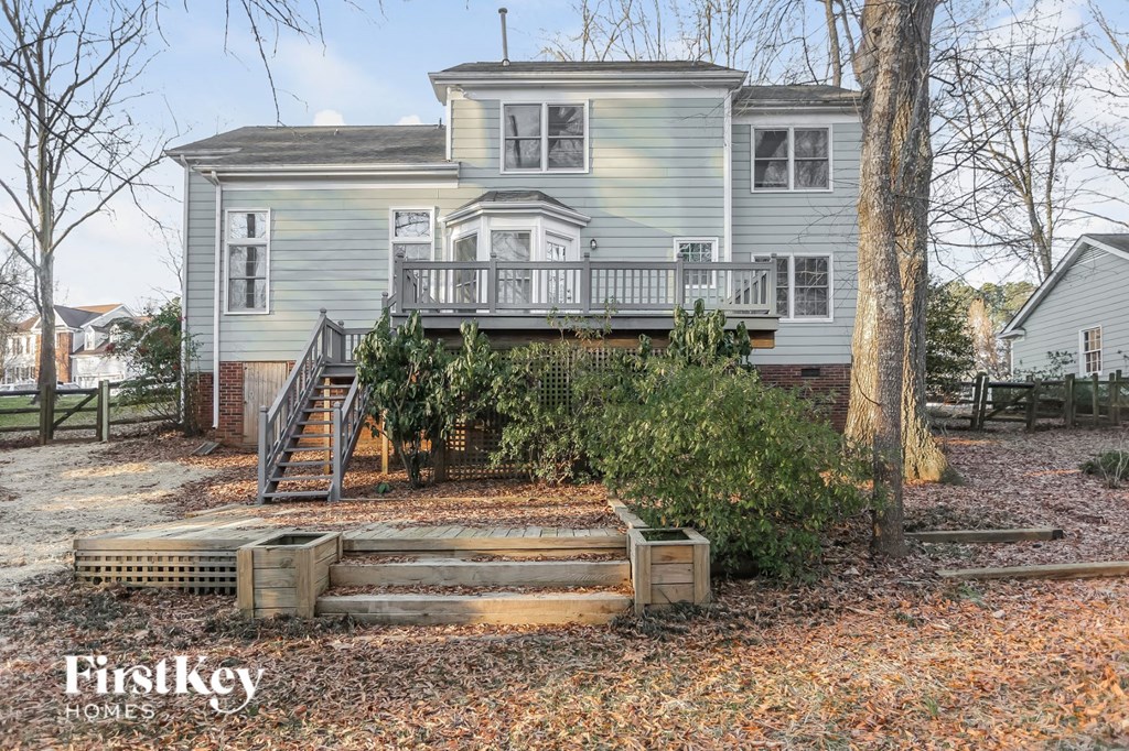 A house with a grey exterior and a deck in the front yard.