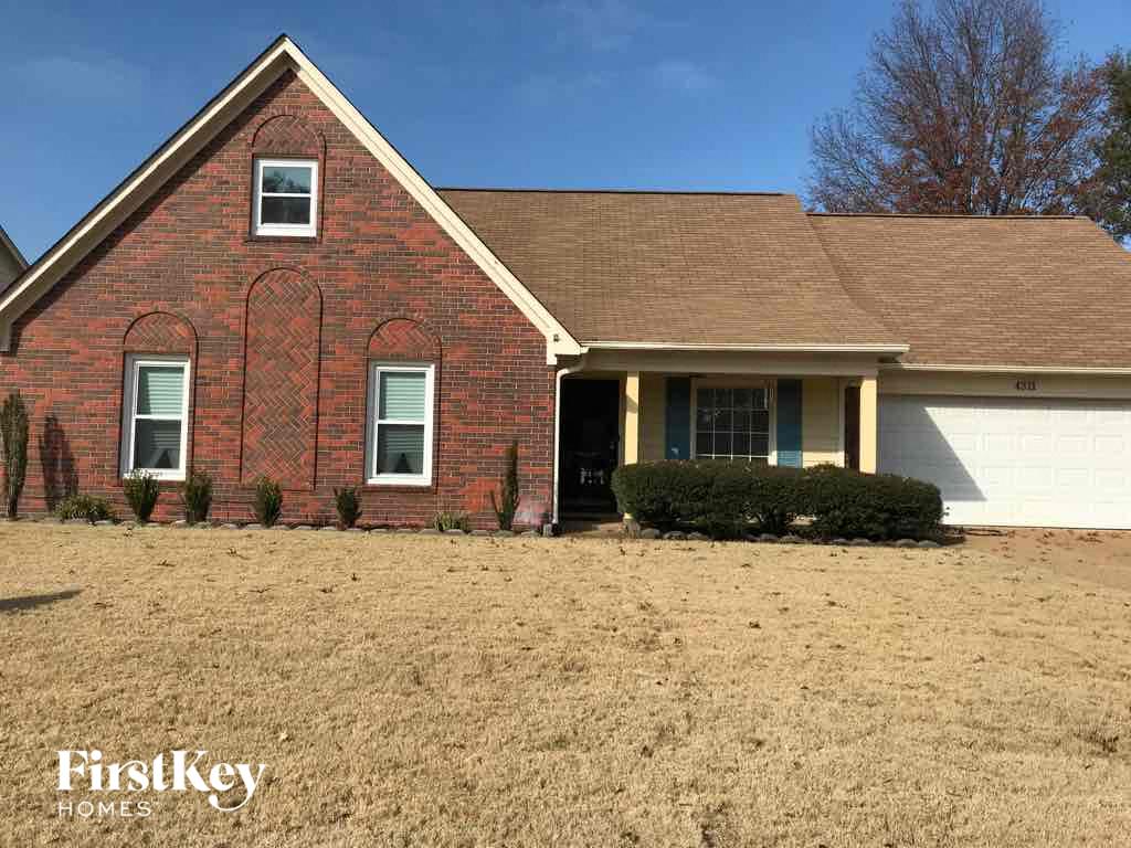 a brick house with a grassy yard in front of it