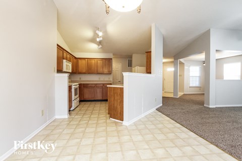 A kitchen with white appliances and wooden cabinets.