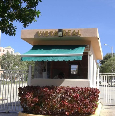 A Vista Real sign is on top of a building with a green awning.