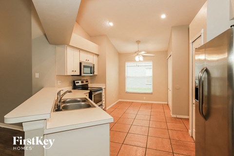 a kitchen with a sink and a stainless steel refrigerator