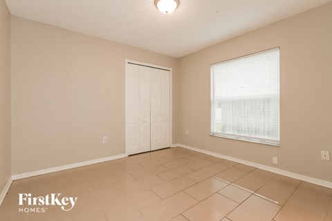 a living room with a door and a window and a tiled floor
