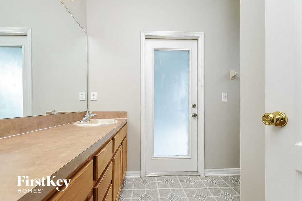a bathroom with a sink and a mirror and a white door