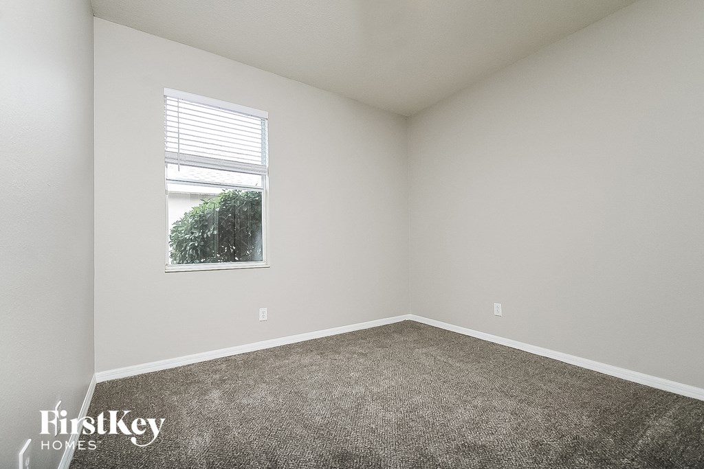 an empty room with carpet and a window