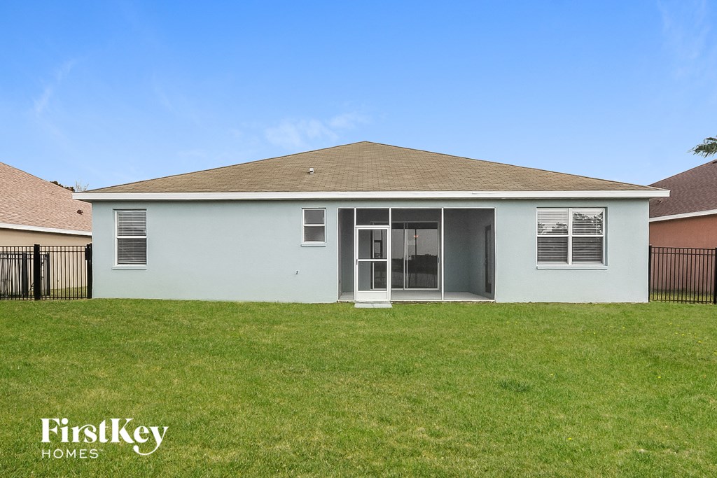 a white house with a grass yard and a fence