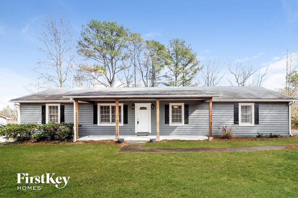 a blue house with a white door and a green lawn