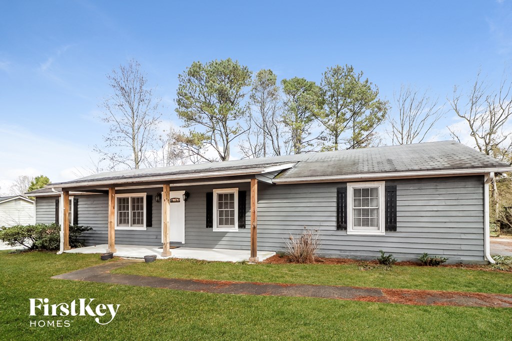 a blue house with a green lawn and trees