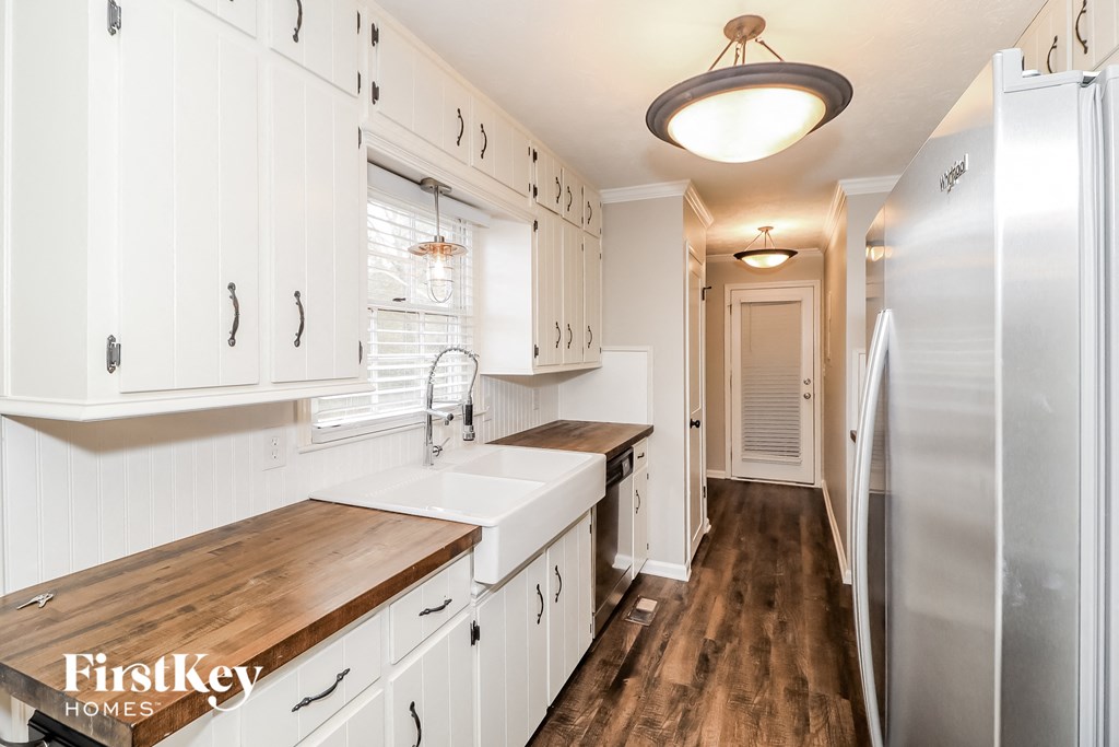 a kitchen with white cabinets and a stainless steel refrigerator