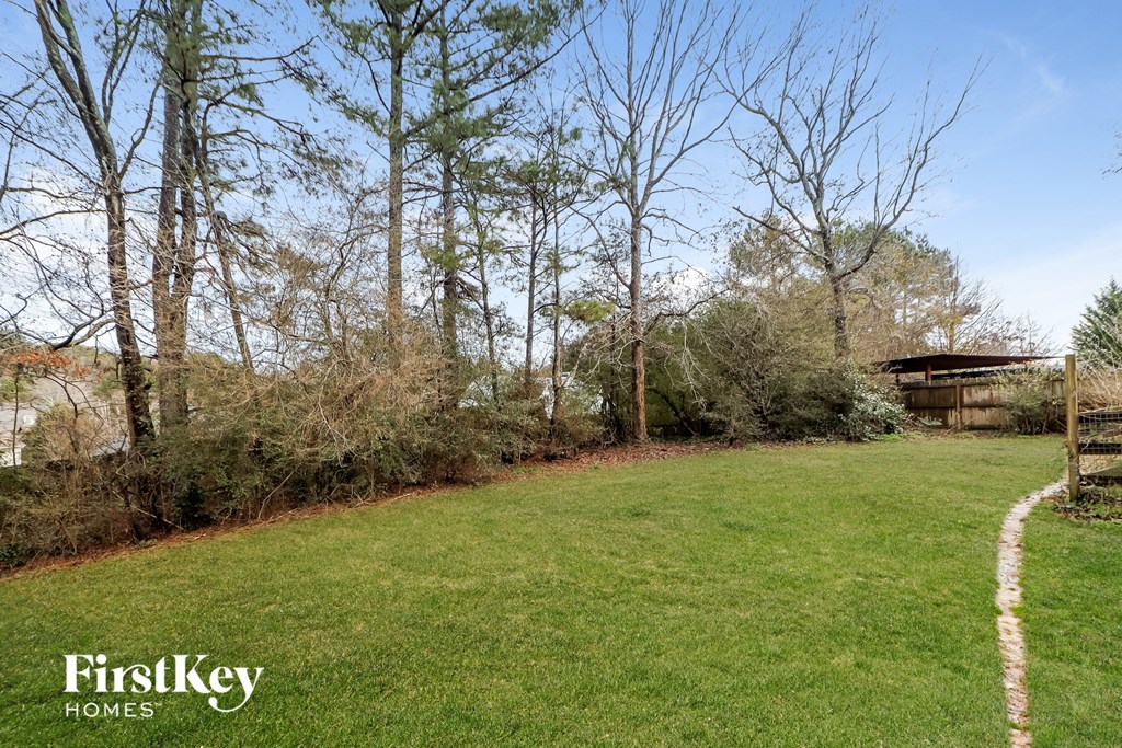 a yard with trees and a house in the background