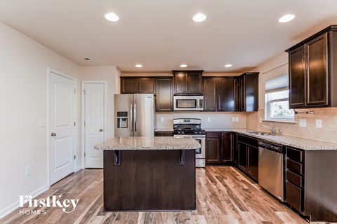 a kitchen with dark wood cabinets and granite counter tops and stainless steel appliances