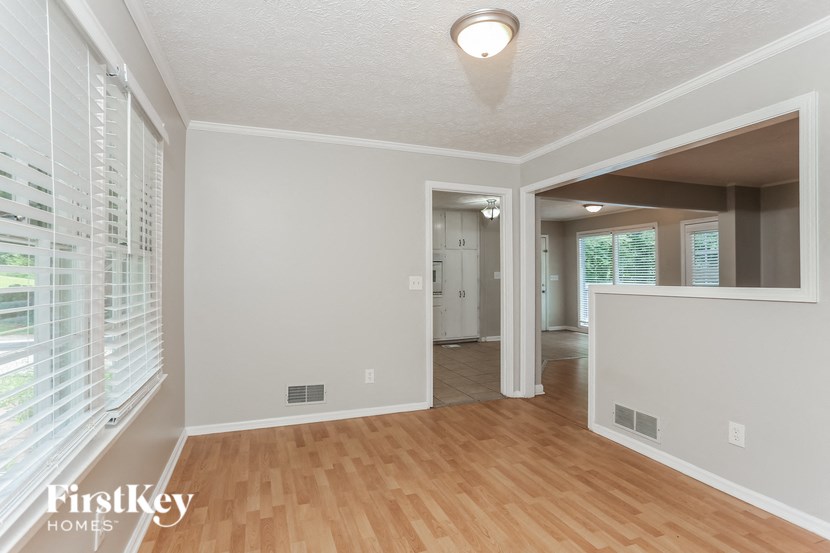 a living room and dining room with wood floors and white walls