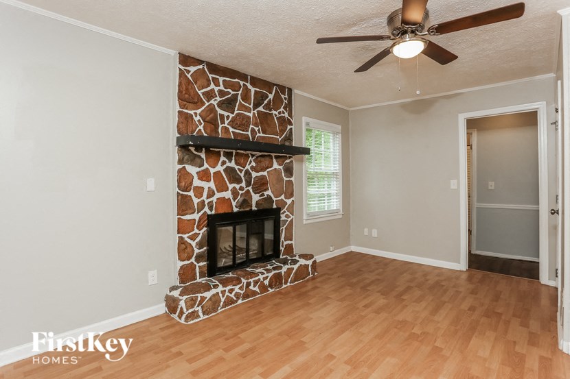 a living room with a fireplace and a ceiling fan