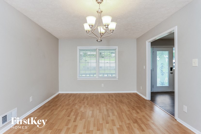 the spacious dining room with hardwood flooring and a chandelier