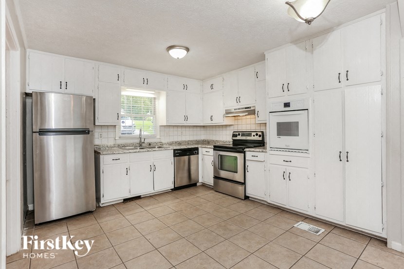 a white kitchen with white cabinets and stainless steel appliances