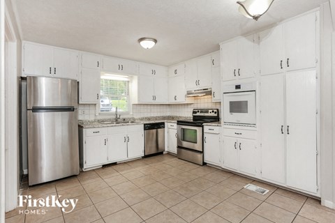 a white kitchen with white cabinets and stainless steel appliances