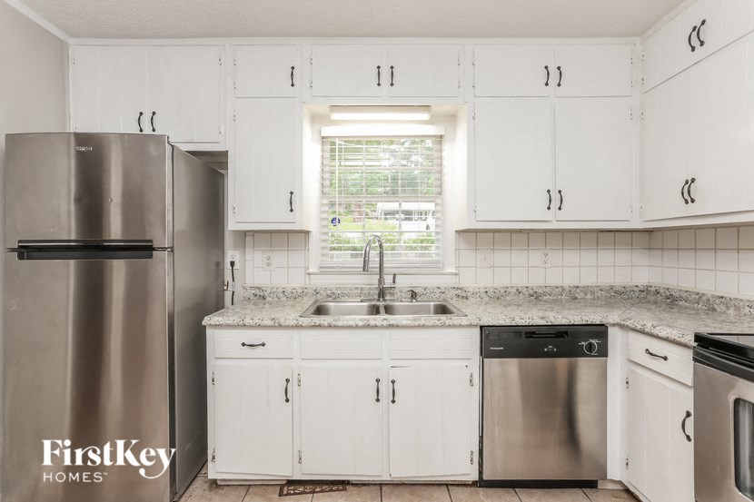 a white kitchen with white cabinets and stainless steel appliances