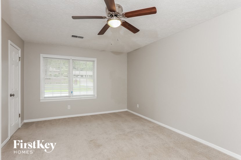 a bedroom with a ceiling fan and a window