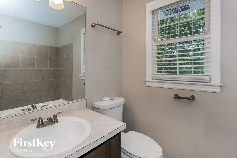 a bathroom with a sink toilet and a mirror