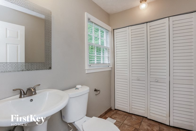 a bathroom with a toilet and a sink and a window