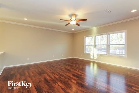 a living room with wood floors and a ceiling fan
