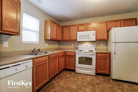A kitchen with wooden cabinets and a white refrigerator.