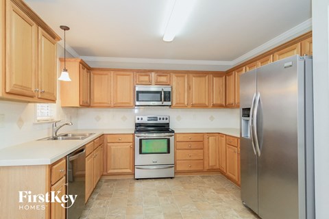 a kitchen with wooden cabinets and stainless steel appliances