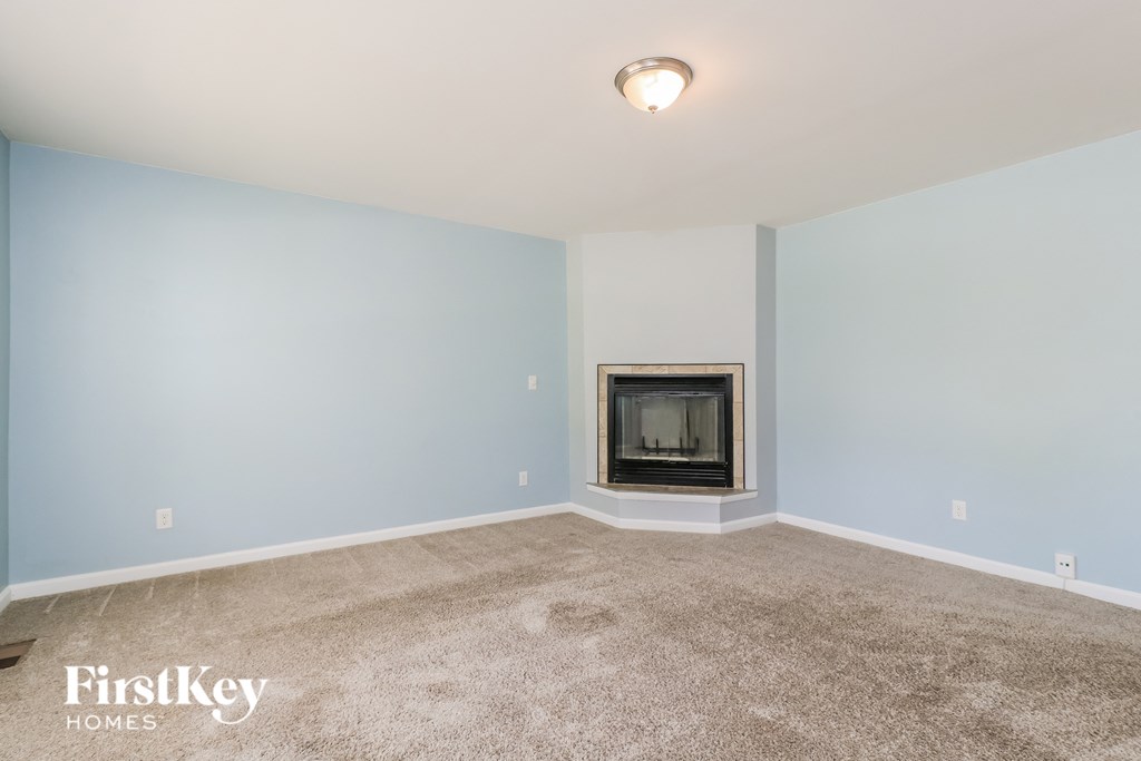 A room with a fireplace and a light blue wall.