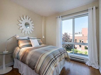 Excelsior Apartments bedroom with large window and hardwood flooring in Montreal, QC - Photo Gallery 8