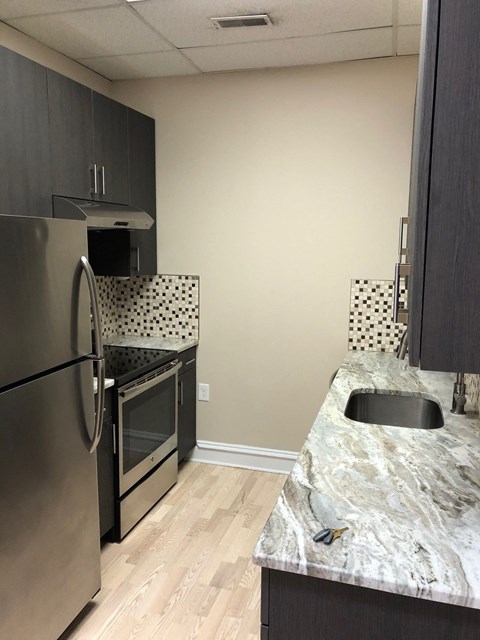 a kitchen with stainless steel appliances and a marble counter top